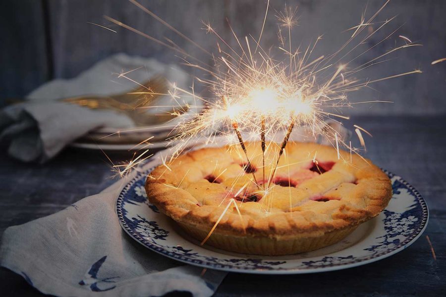 A homemade pie with sparklers sticking out of the top