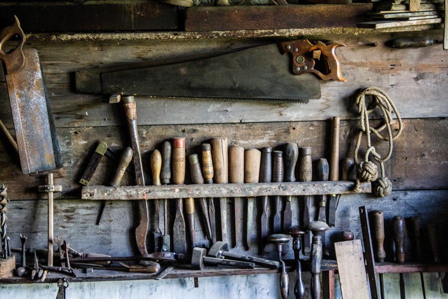 Various woodworking tools hung on a woodshop wall