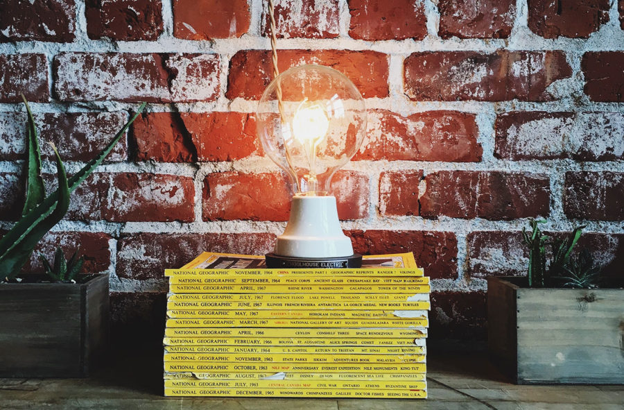 An exposed lightbulb sitting atop a pile of books