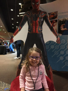 My daughter standing in front of a Spider-man cardboard cut-out at a sponsor booth