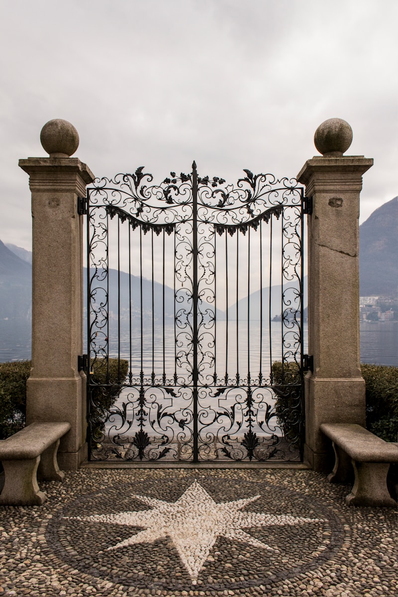 An ornate, metal gate overlooking a body of water